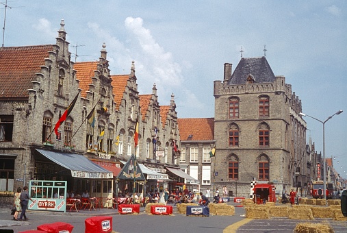 Grote Markt, Veurne, West Flanders, Belgium, 1964. The market square of Veurne with its old town houses with stepped gables. In addition: street cafes, bistros, guests, pedestrians and a motorcycle rental.