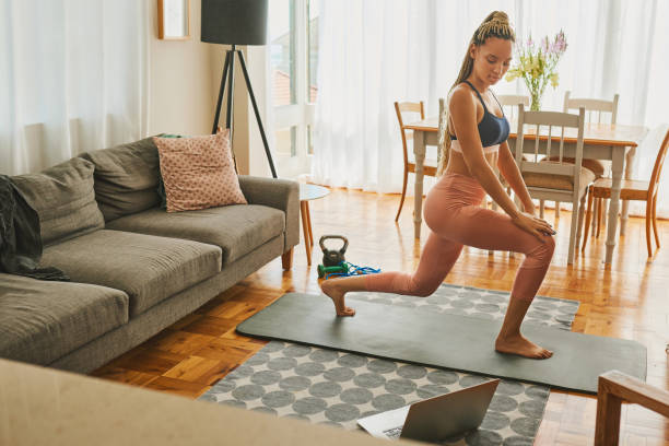 istock Shot of a young woman using a laptop while exercising at home 1326163213
