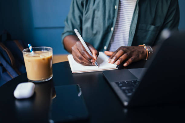 istock An Anonymous Businessman Writing Notes in a Notebook at Cafe 1326166000
