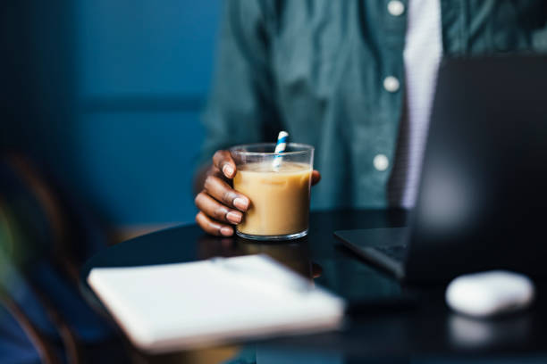 istock An Anonymous Businessman Holding Glass with Iced Coffee while Working on his Laptop Computer in a Coffee Shop 1326166008