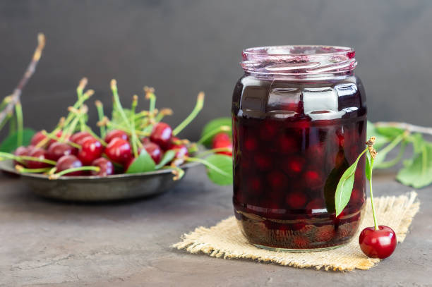sauerkirsche marmelade in glas mit frischen rohen sauerkirschen - sour cherry stock-fotos und bilder
