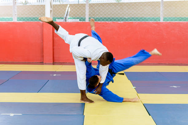 athlète de judo entrant dans le coup pendant le combat - judo photos et images de collection