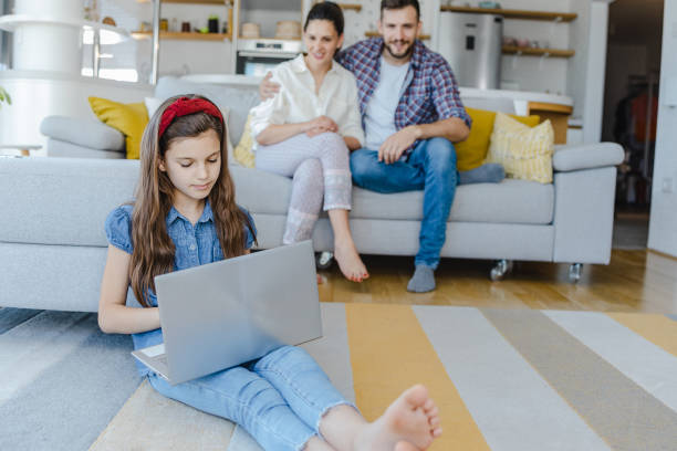 istock Little girl is using laptop at home 1326168423