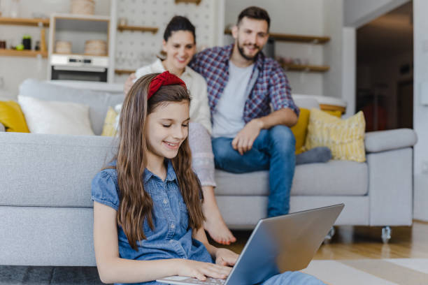istock Little girl is using laptop at home 1326169144