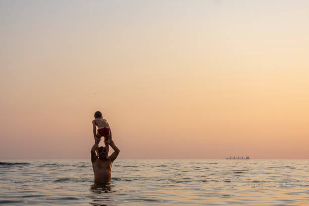 Father and Son Playing on the Beach at Sunset.Family who enjoy a picnic.Family, travel,beach, relax,lifestyle, holiday concept.