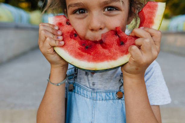 istock Adorable boy standing outdoors and eating watermelon 1326170153