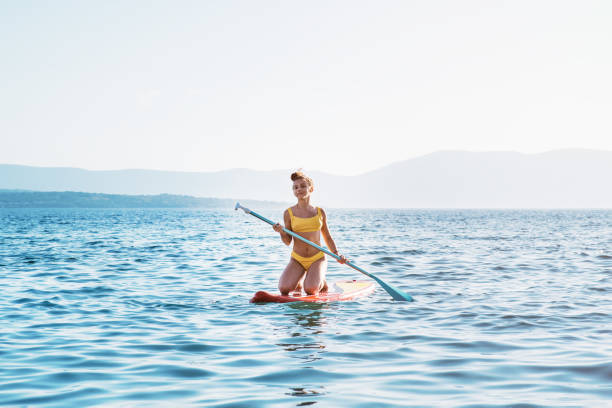istock A beautiful girl at the beach with her surf board. 1326179070