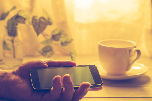 Hand holding coffee and smartphone
