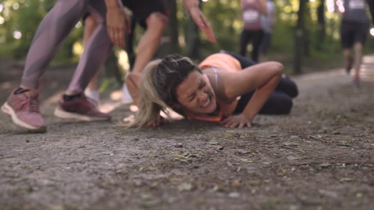 Female athlete falling to the ground during marathon.