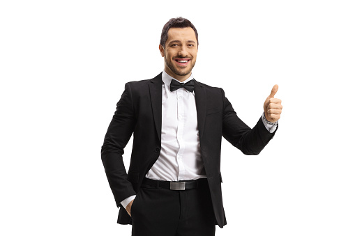 Elegant man in a suit and bow showing thumbs up isolated on white background