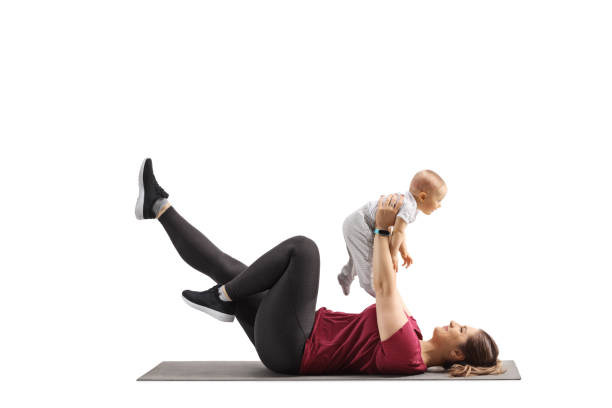 young mother laying on a carpet and exercising with her baby - mother exercising baby dieting imagens e fotografias de stock