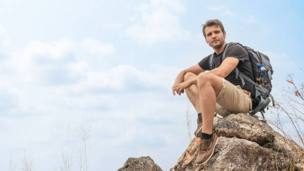istock caucasian backpack hiker sitting on rock for resting during walking on trekking trail on mountain on summer sport journey leisure 1326187935