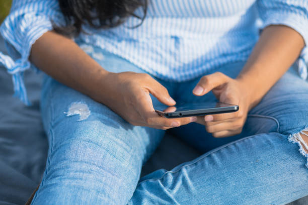 istock Latin woman chatting with mobile in the tree 1326191192