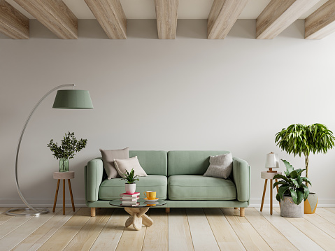 Sofá verde en el interior del apartamento moderno con pared vacía y mesa de madera. photo
