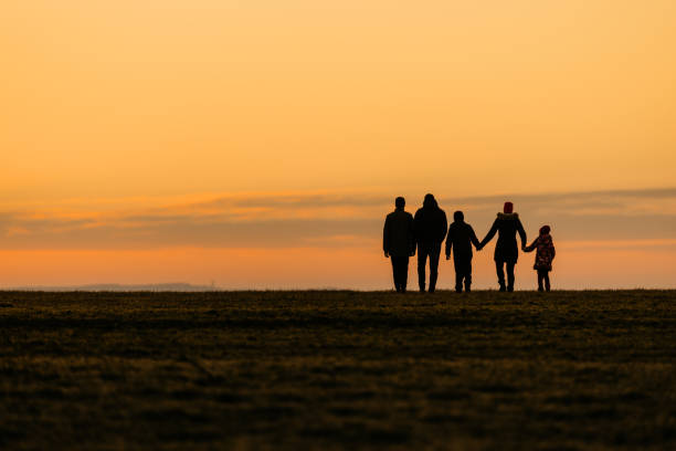 Family walking at distance on dry grassy land
