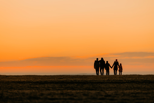 Family walking together at distance during dusk