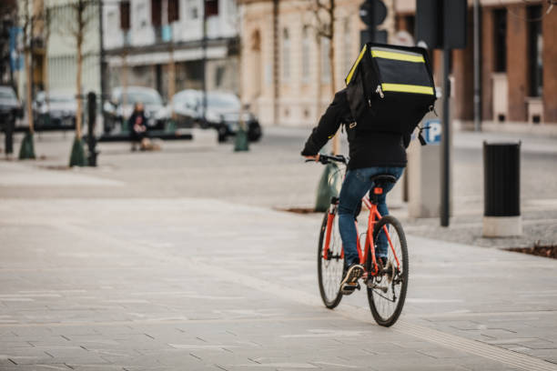 istock Delivery man with food back pack riding bicycle 1326201971