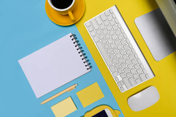 istock Mock up computer, notepad, coffee cup and mobile phone on blue and yellow background. 1326202577