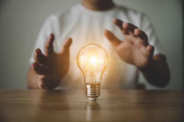 istock Hand holding light bulb on wood table. Concept of inspiration creative idea thinking and future technology innovation 1326203363
