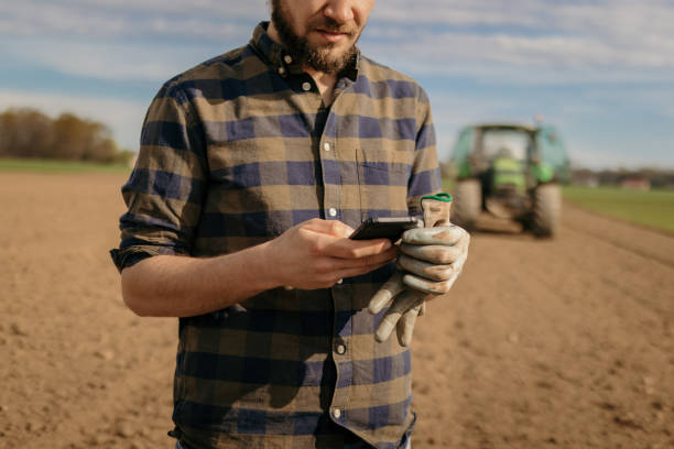 istock Close up of a farmer using phone 1326203398