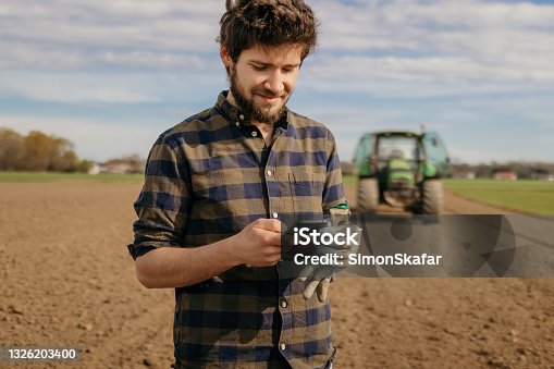 istock Portrait of a farmer using smartphone 1326203400