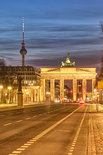 The famous Brandenburg Gate in Berlin with the Television Tower at twilight