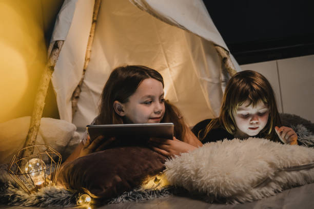 istock Cute girls playing their smartphone and tablet 1326204525