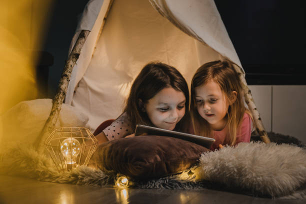 istock Two little girls using digital tablet in tent at home 1326204528