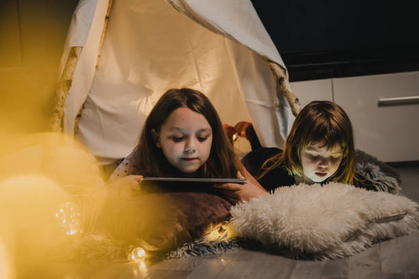istock Sisters playing on their smartphones 1326204534