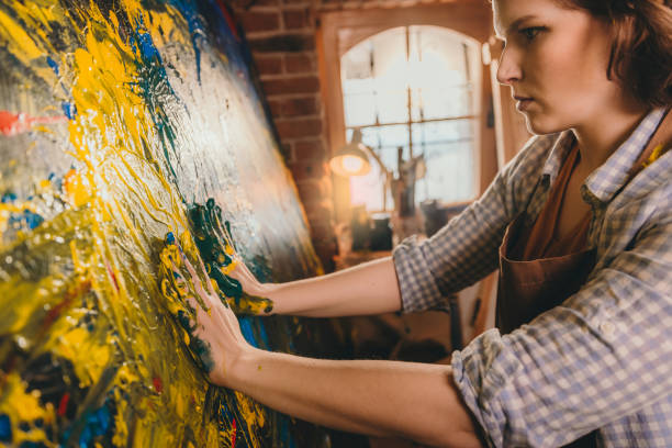 istock Female artist painting with hands on canvas 1326207332