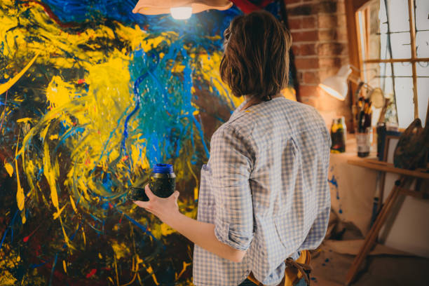 istock Artist with paint bottle while painting 1326207471