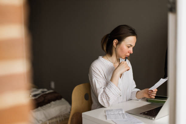 istock Young woman analyzing bills at home 1326209639