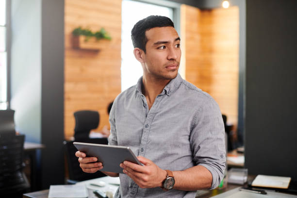 istock Shot of a young businessman using a digital tablet in a modern office 1326211241