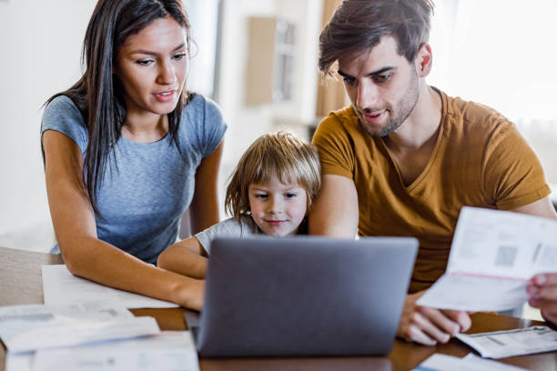 istock Happy family paying bills over a computer at home. 1326211313