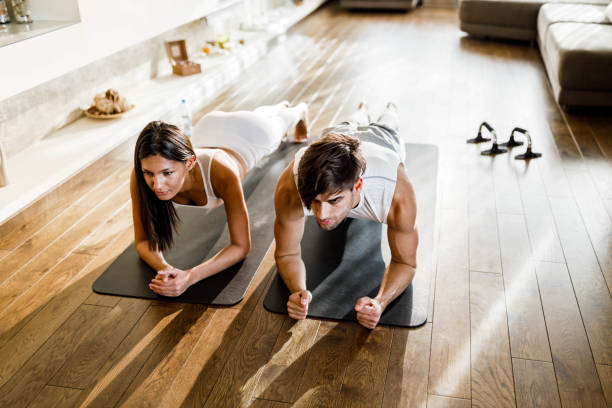 istock Athletic couple exercising endurance in a plank position at home. 1326211336