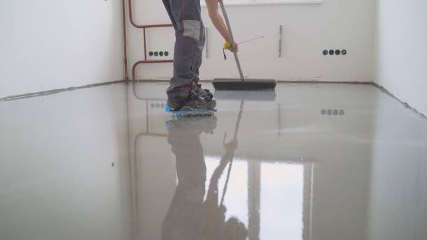istock Master with a needle roller. Filling the floor. A contractor painter will paint the garage floor to speed up the sale of your home. Floor screed filling, repair and finishing. Fill in the low spots with self-leveling compound for a fine leveling. Cement 1326214396