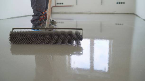 istock Master with a needle roller. Filling the floor. A contractor painter will paint the garage floor to speed up the sale of your home. Floor screed filling, repair and finishing. Fill in the low spots with self-leveling compound for a fine leveling. Cement 1326214400