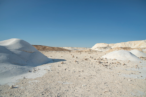 Beautiful lunar landscape. Wight and smooth hills in various shapes in a desert landscape. The whitish, rounded, winding, and smooth chalk rocks. Israel. High quality photo