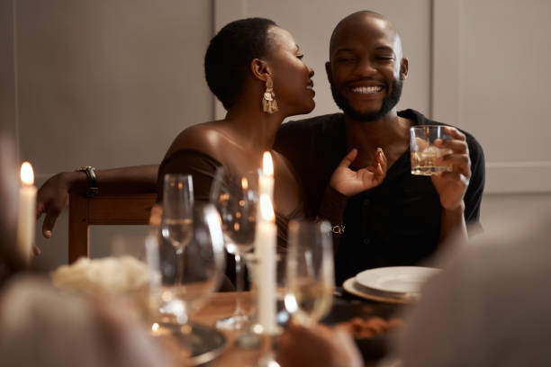 scatto di una giovane coppia felice seduta insieme e legato durante una cena di capodanno - champagne celebration glass black foto e immagini stock