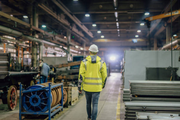 istock Foreman with other workers working in factory 1326216819