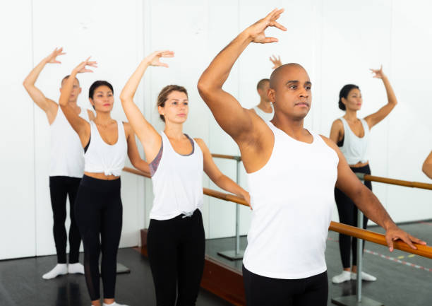 istock Group of people doing ballet exercises using  barre in  gym 1326217872