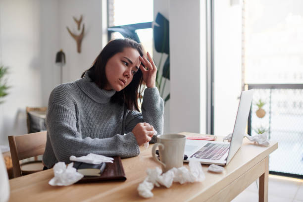 Shot of a woman feeling unwell while working from home stock photo