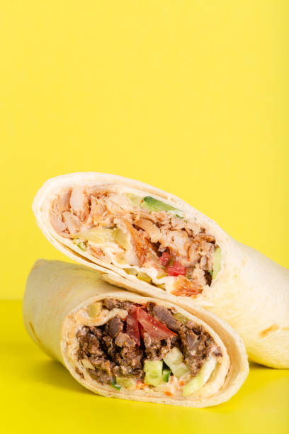 istock Doner roll shawarma with chicken and vegetables on yellow 1326219008