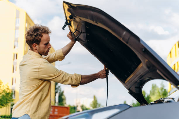 istock Close-up portrait, young man having problems with broken car, opening hood trying to fix engine. The machine will not start. 1326221235