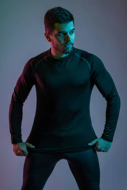 istock Young man in black sportswear confidently posing in studio 1326221975