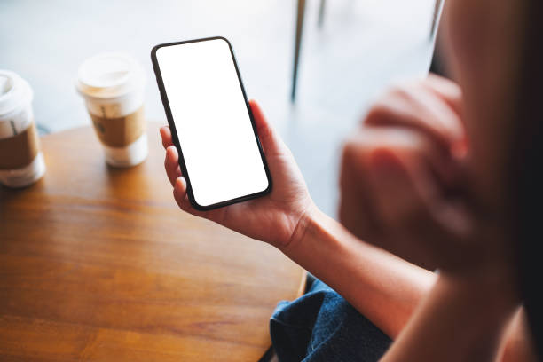 istock a woman holding mobile phone with blank white desktop screen 1326222094