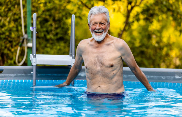 istock Senior man laughing in the pool 1326222266