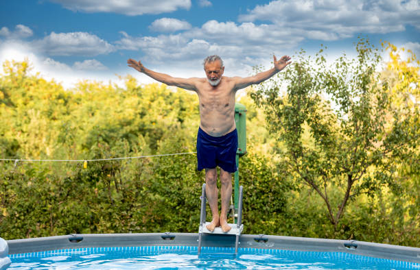 istock Senior man laughing in the pool 1326222271