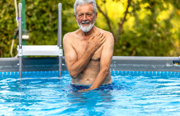 istock Senior man laughing in the pool 1326222278