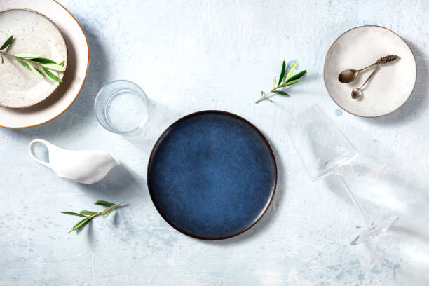 Modern tableware, overhead flat lay shot with a blue plate and olive branches